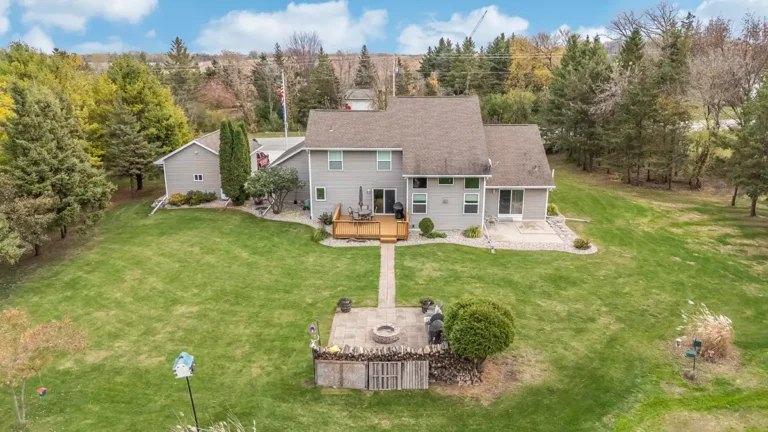 Aerial view of a large two-story home with a backyard firepit.